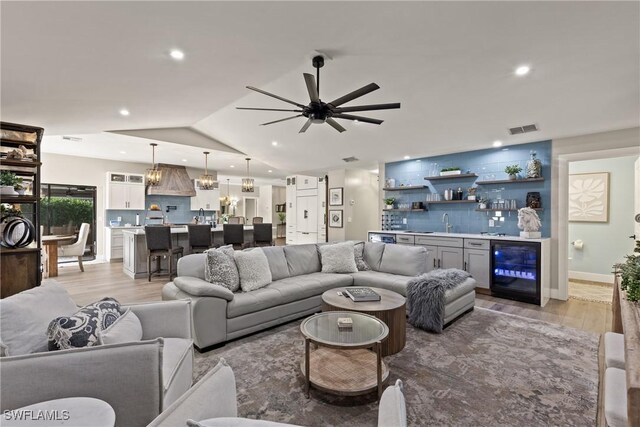 1020 SW 56th St, Cape Coral, FL 33914 - living room with wine cooler, bar area, light wood-style flooring, a ceiling fan, and recessed lighting