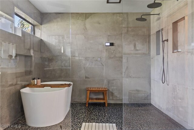 1020 SW 56th St, Cape Coral, FL 33914 - bathroom featuring a walk in shower, a freestanding tub, and tile walls