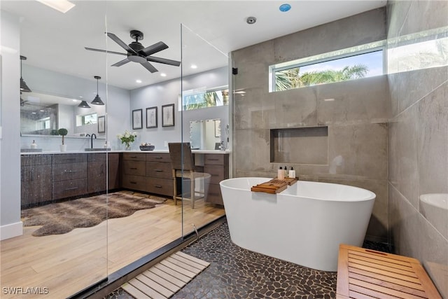 1020 SW 56th St, Cape Coral, FL 33914 - full bath featuring a freestanding tub, vanity, a ceiling fan, tile walls, and recessed lighting