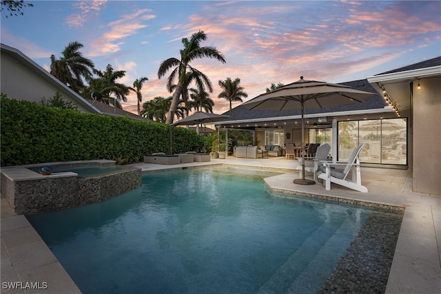 1020 SW 56th St, Cape Coral, FL 33914 - pool at dusk with outdoor lounge area, a patio, and a pool with connected hot tub