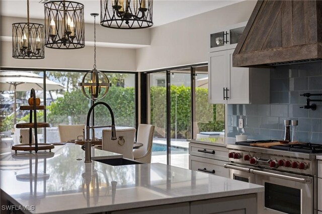 1020 SW 56th St, Cape Coral, FL 33914 - kitchen featuring double oven range, custom exhaust hood, a chandelier, and tasteful backsplash