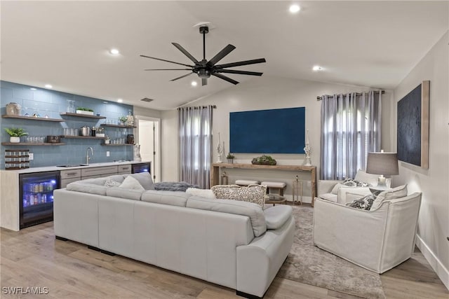 1020 SW 56th St, Cape Coral, FL 33914 - living room featuring beverage cooler, bar with sink, lofted ceiling, a ceiling fan, and light wood-style floors