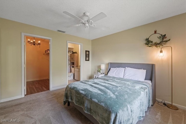 503 Cape Coral Pkwy W Unit 201, Cape Coral, FL 33914 - carpeted bedroom featuring a chandelier, baseboards, a walk in closet, a ceiling fan, and a textured ceiling
