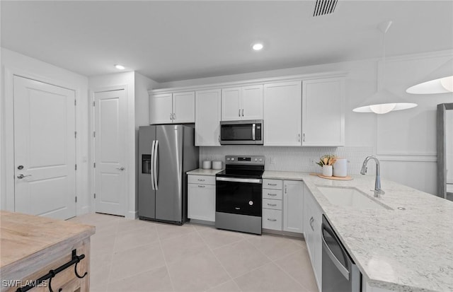 6470 Memorial Ln, Ave Maria, FL 34142 - kitchen featuring stainless steel appliances, a sink, white cabinetry, light stone counters, and a peninsula
