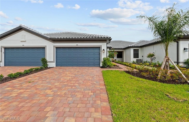 6470 Memorial Ln, Ave Maria, FL 34142 - view of front of house featuring decorative driveway, a garage, stucco siding, a tiled roof, and a front yard