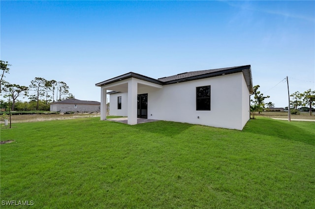 1925 NW 30th Ter, Cape Coral, FL 33993 - rear view of house featuring a yard, stucco siding, and a patio