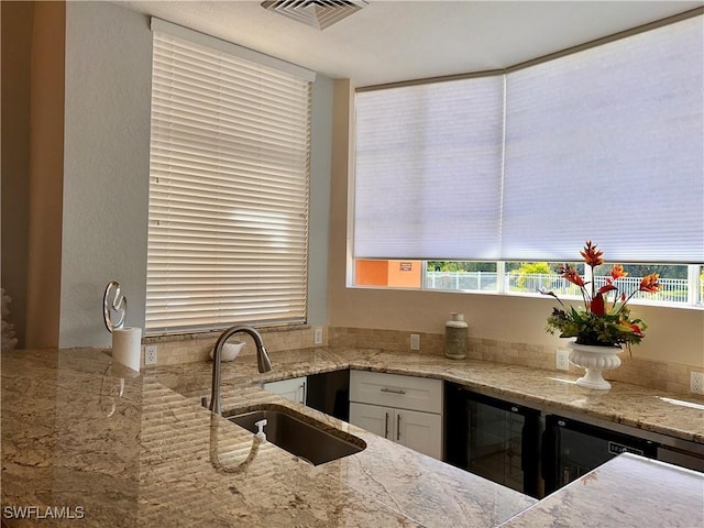 6401 Aragon Way Unit 102, Fort Myers, FL 33966 - kitchen with a sink, beverage cooler, plenty of natural light, and white cabinetry