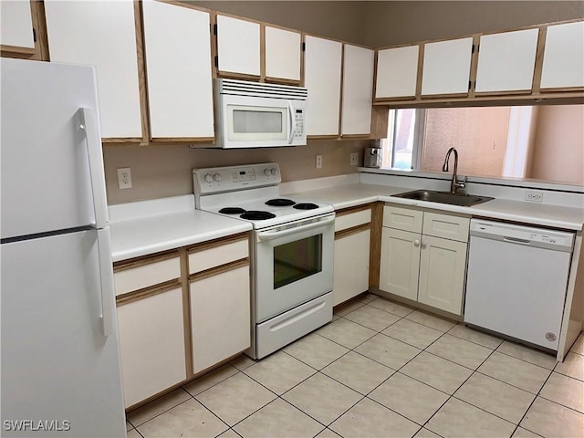 6401 Aragon Way Unit 102, Fort Myers, FL 33966 - kitchen featuring white appliances, a sink, light countertops, light tile patterned floors, and white cabinetry