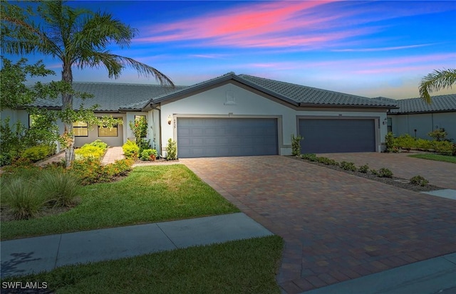 6459 Memorial Ln, Ave Maria, FL 34142 - view of front of house with decorative driveway, a garage, stucco siding, a tiled roof, and a front yard