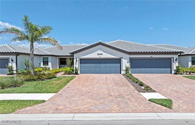 6459 Memorial Ln, Ave Maria, FL 34142 - ranch-style house featuring stucco siding, an attached garage, decorative driveway, and a tiled roof