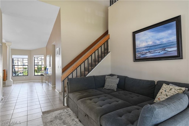 17260 Eagle Trce Unit 10, Fort Myers, FL 33908 - living room with light tile patterned flooring, stairs, baseboards, decorative columns, and a high ceiling