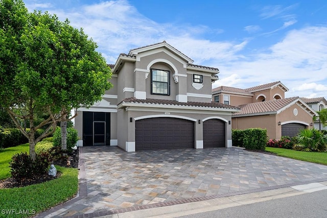 11651 Oakwood Preserve Pl, Fort Myers, FL 33913 - mediterranean / spanish house with a garage, stucco siding, decorative driveway, and a tile roof