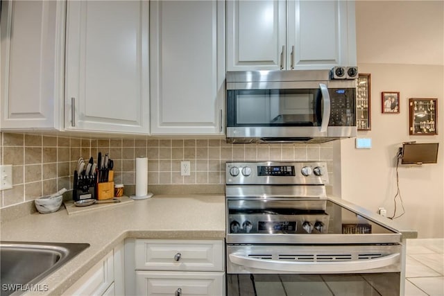 7116 Blanquilla Ct Unit 220, Fort Myers, FL 33908 - kitchen with stainless steel appliances, white cabinets, backsplash, and light countertops