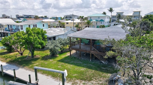171 Primo Dr, Fort Myers Beach, FL 33931 - rear view of house featuring a residential view, a lawn, a wooden deck, and stairway