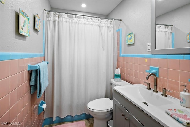 171 Primo Dr, Fort Myers Beach, FL 33931 - full bath with tile walls, toilet, vanity, wainscoting, and a shower with shower curtain