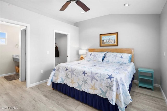 171 Primo Dr, Fort Myers Beach, FL 33931 - bedroom with light wood finished floors, vaulted ceiling, baseboards, and ensuite bathroom