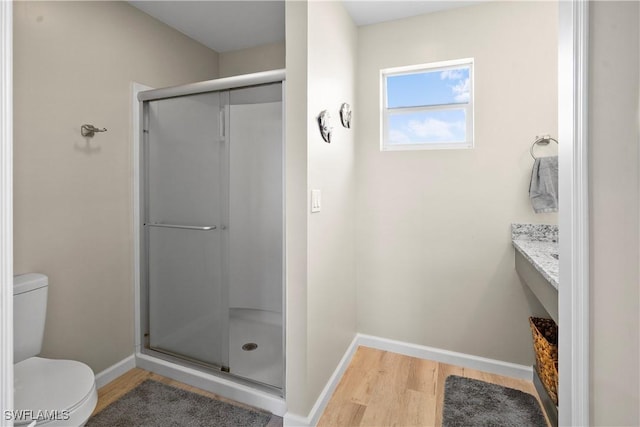171 Primo Dr, Fort Myers Beach, FL 33931 - bathroom featuring wood finished floors, toilet, baseboards, a stall shower, and vanity