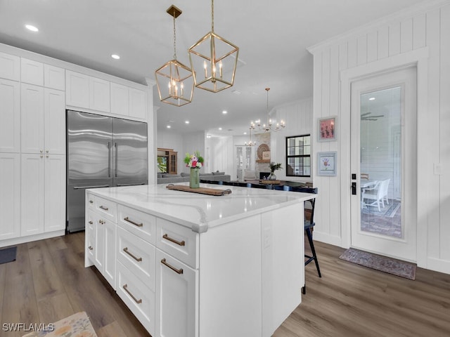 16970 Laurelin Ct, North Fort Myers, FL 33917 - kitchen with built in refrigerator, a chandelier, white cabinetry, a center island, and pendant lighting