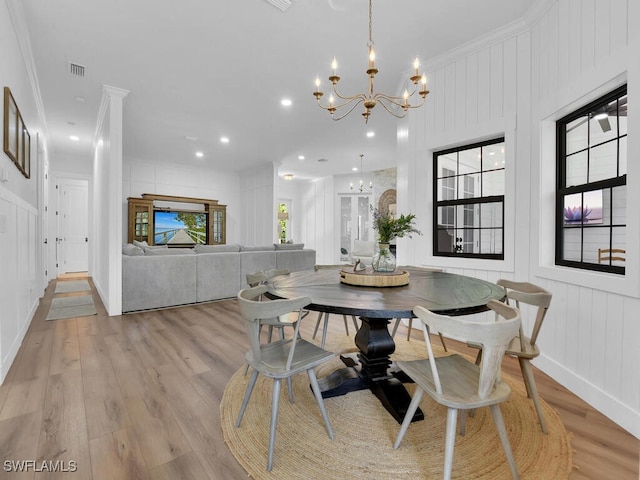 16970 Laurelin Ct, North Fort Myers, FL 33917 - dining room with a chandelier, a decorative wall, light wood finished floors, ornamental molding, and baseboards