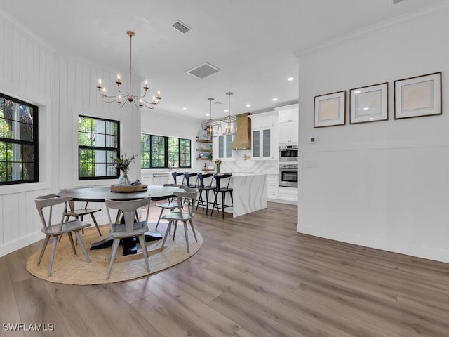 16970 Laurelin Ct, North Fort Myers, FL 33917 - dining area with a chandelier, crown molding, wood finished floors, a decorative wall, and recessed lighting