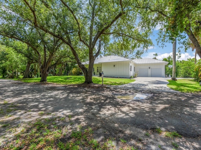 16970 Laurelin Ct, North Fort Myers, FL 33917 - single story home with a garage, driveway, a front yard, and metal roof