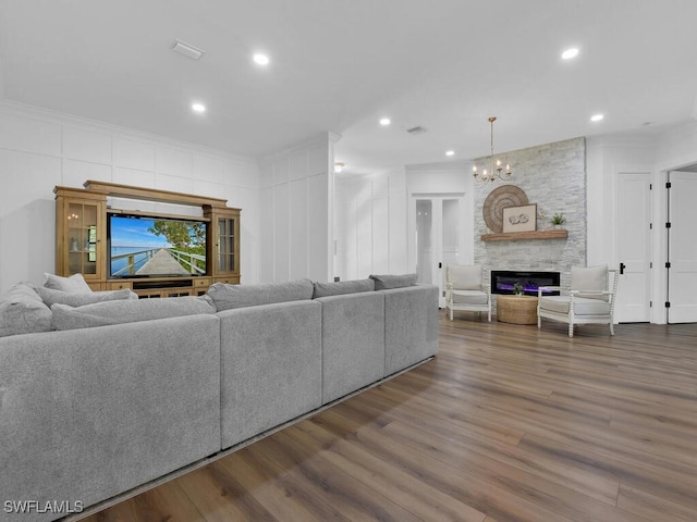 16970 Laurelin Ct, North Fort Myers, FL 33917 - living room featuring wood finished floors, recessed lighting, a chandelier, a stone fireplace, and ornamental molding