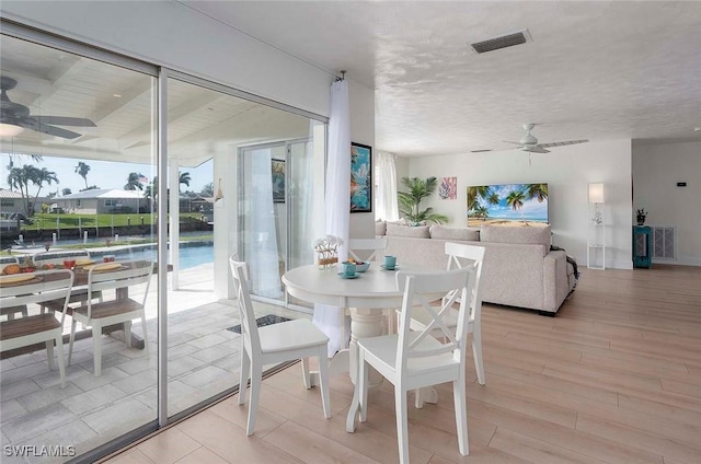 1432 Wellington Ct, Cape Coral, FL 33904 - dining area with ceiling fan, light wood-style floors, and a textured ceiling