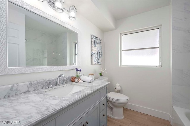 1432 Wellington Ct, Cape Coral, FL 33904 - bathroom featuring vanity, wood finished floors, baseboards, toilet, and bathtub / shower combination
