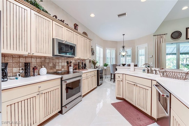 3181 Bramble Cove Ct, Fort Myers, FL 33905 - kitchen with appliances with stainless steel finishes, cream cabinetry, backsplash, pendant lighting, and light countertops