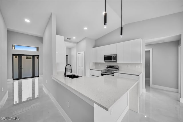814 Edward Ave, Lehigh Acres, FL 33936 - kitchen with appliances with stainless steel finishes, a sink, white cabinetry, baseboards, and lofted ceiling