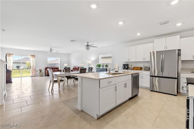 4005 Cavassa Ct, North Fort Myers, FL 33917 - kitchen with stainless steel appliances, a sink, a ceiling fan, open floor plan, and white cabinetry