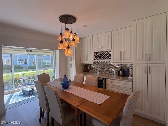 3358 N Key Dr Unit 2, North Fort Myers, FL 33903 - dining space featuring a dry bar, beverage cooler, and wood finished floors