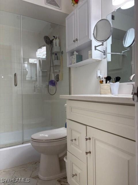 3358 N Key Dr Unit 2, North Fort Myers, FL 33903 - bathroom featuring an enclosed shower, vanity, toilet, and marble look tile flooring