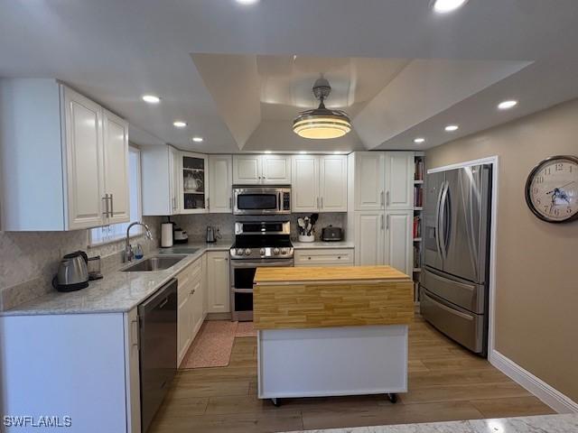 3358 N Key Dr Unit 2, North Fort Myers, FL 33903 - kitchen with appliances with stainless steel finishes, a sink, recessed lighting, light wood finished floors, and white cabinetry