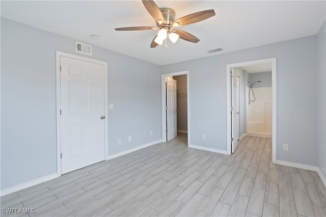 2208/2210 Haviland Ave S, Lehigh Acres, FL 33973 - unfurnished bedroom with light wood-style floors, baseboards, a walk in closet, a ceiling fan, and a closet