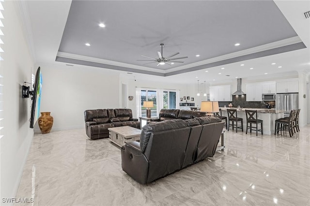 2228 SW 15th Ave, Cape Coral, FL 33991 - living room with a tray ceiling, light marble finish flooring, a ceiling fan, crown molding, and baseboards