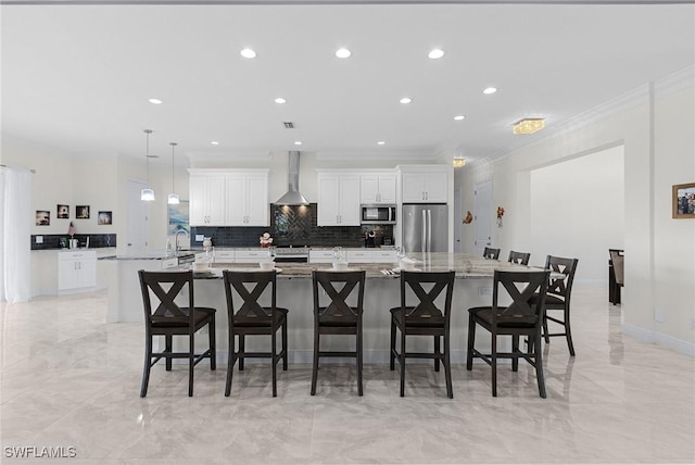 2228 SW 15th Ave, Cape Coral, FL 33991 - kitchen featuring appliances with stainless steel finishes, white cabinets, wall chimney exhaust hood, a spacious island, and recessed lighting