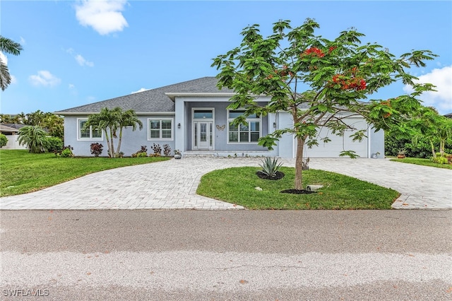 2228 SW 15th Ave, Cape Coral, FL 33991 - view of front of home featuring decorative driveway, stucco siding, a front lawn, and roof with shingles