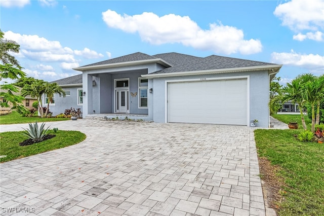 2228 SW 15th Ave, Cape Coral, FL 33991 - view of front facade featuring decorative driveway, stucco siding, a garage, and a front lawn