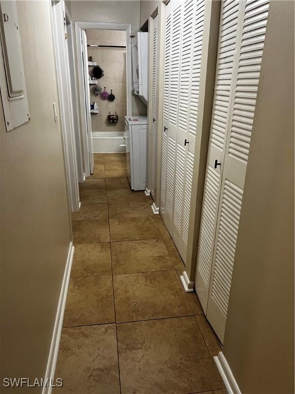 3303 Royal Canadian Trce Unit 4, Fort Myers, FL 33907 - hall featuring washer / dryer, light tile patterned floors, baseboards, and electric panel