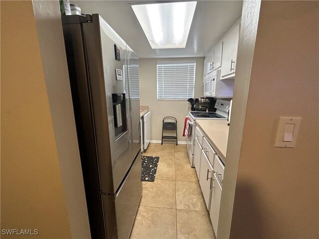 3303 Royal Canadian Trce Unit 4, Fort Myers, FL 33907 - kitchen with white appliances, white cabinetry, light countertops, light tile patterned floors, and washer / dryer