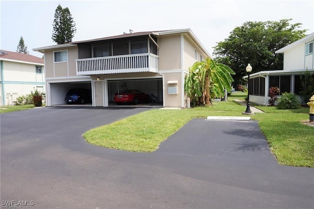 3303 Royal Canadian Trce Unit 4, Fort Myers, FL 33907 - view of front property featuring a sunroom, an attached garage, a front yard, driveway, and stucco siding