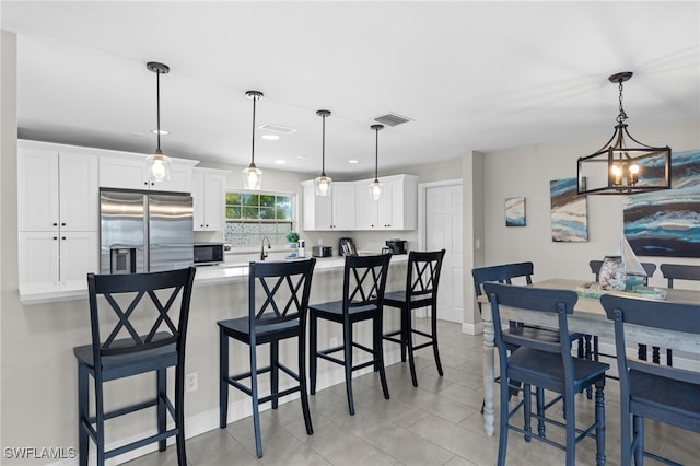 3117 SE 18th Ave, Cape Coral, FL 33904 - kitchen featuring appliances with stainless steel finishes, a chandelier, white cabinetry, a kitchen bar, and a sink