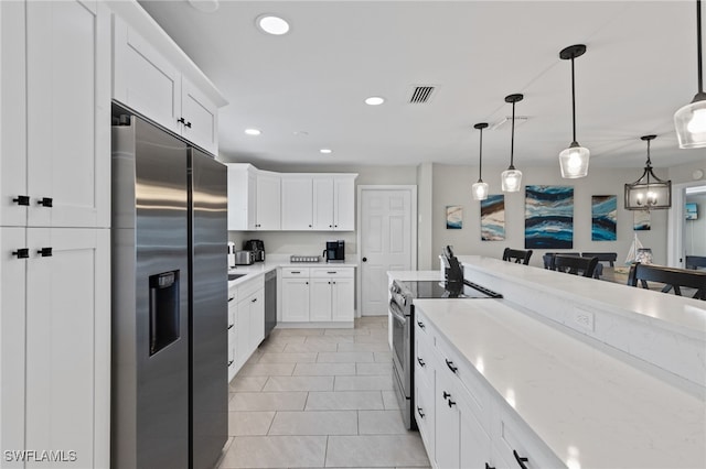 3117 SE 18th Ave, Cape Coral, FL 33904 - kitchen featuring stainless steel appliances, white cabinets, decorative light fixtures, recessed lighting, and light stone countertops