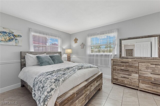 3117 SE 18th Ave, Cape Coral, FL 33904 - bedroom with multiple windows, light tile patterned flooring, and baseboards