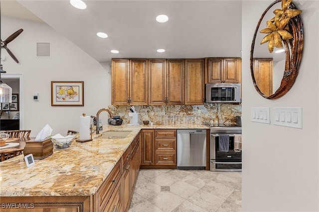 15657 Carriedale Ln, Fort Myers, FL 33912 - kitchen with stainless steel appliances, a sink, brown cabinets, a peninsula, and recessed lighting