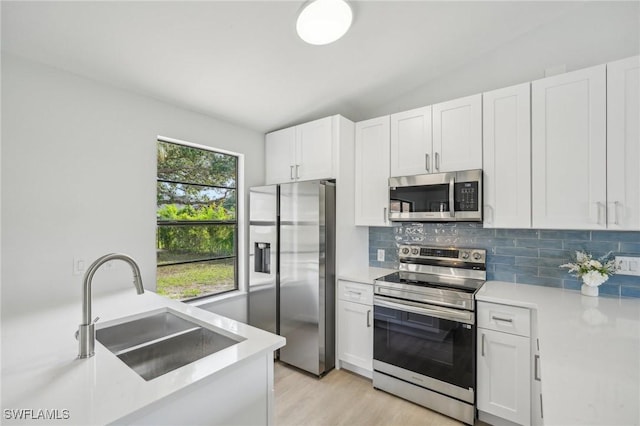 4906 5th St W, Lehigh Acres, FL 33971 - kitchen featuring stainless steel appliances, a sink, decorative backsplash, light countertops, and lofted ceiling
