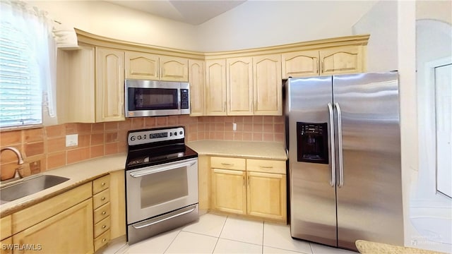 1108 Lee Ave, Lehigh Acres, FL 33972 - kitchen featuring appliances with stainless steel finishes, light brown cabinetry, a sink, and backsplash