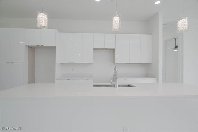 1254 Nimitz Blvd, Lehigh Acres, FL 33974 - kitchen featuring a sink, white cabinets, light countertops, recessed lighting, and hanging light fixtures