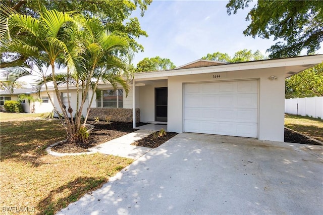 1644 N Hermitage Rd, Fort Myers, FL 33919 - ranch-style home with concrete driveway, an attached garage, stucco siding, and stone siding